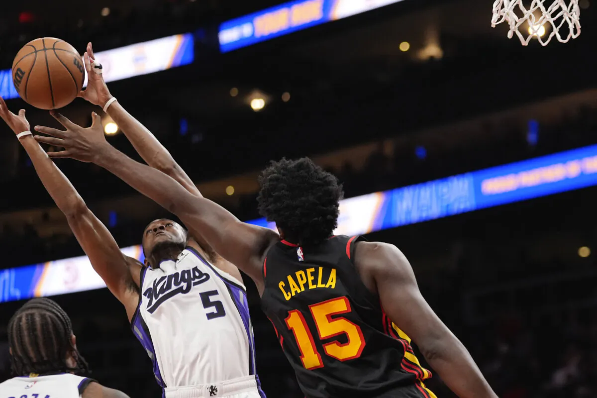Sacramento Kings guard De'Aaron Fox (5) battles Atlanta Hawks center Clint Capela (15) for a rebound during the first half of an NBA basketball game in Atlanta, on Nov. 1, 2024. (John Bazemore/AP Photo)