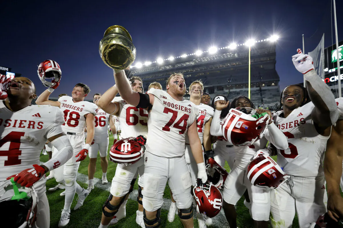Indiana players, including offensive lineman Bray Lynch (74), celebrate with the Old Brass Spitoon after defeating Michigan State in an NCAA college football game in East Lansing, Mich., on Nov. 2, 2024. (AP Photo/Al Goldis)