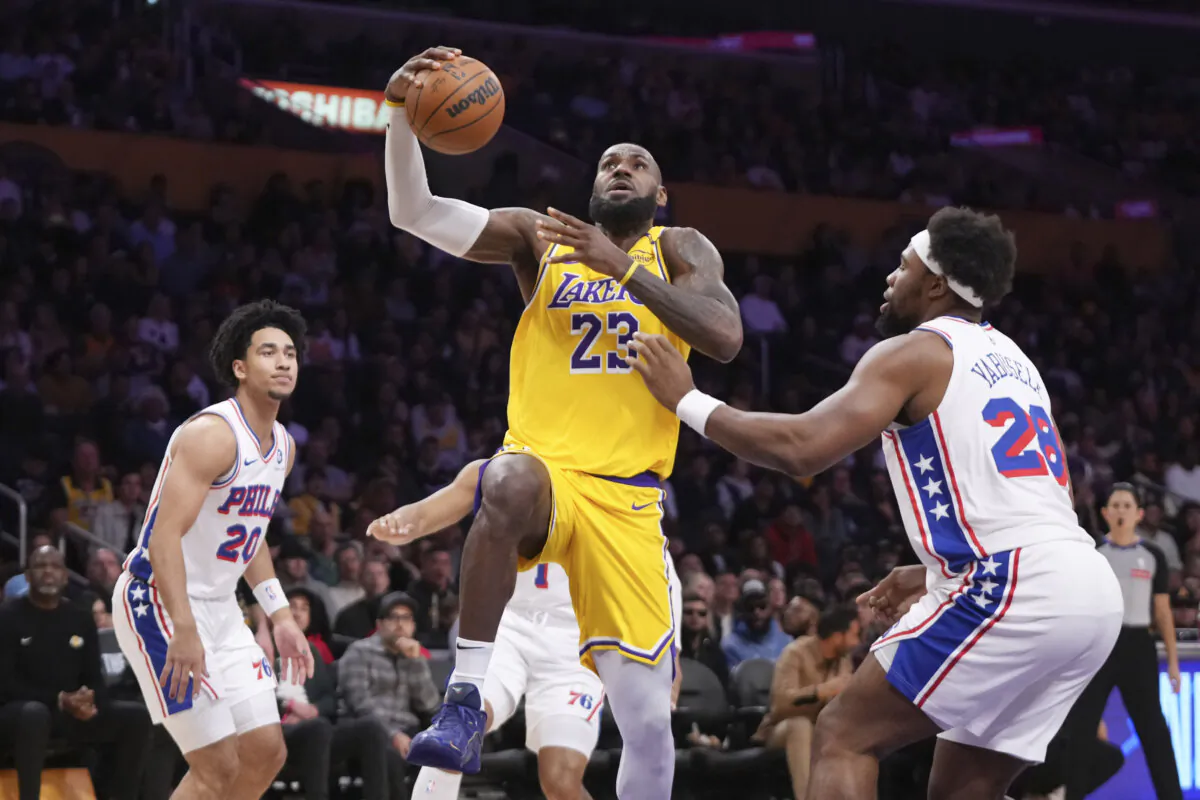 Los Angeles Lakers forward LeBron James, center, shoots as Philadelphia 76ers guard Jared McCain, left, and forward Guerschon Yabusele defend during the first half of an NBA basketball game in Los Angeles, on Nov. 8, 2024. (Mark J. Terrill/AP Photo)