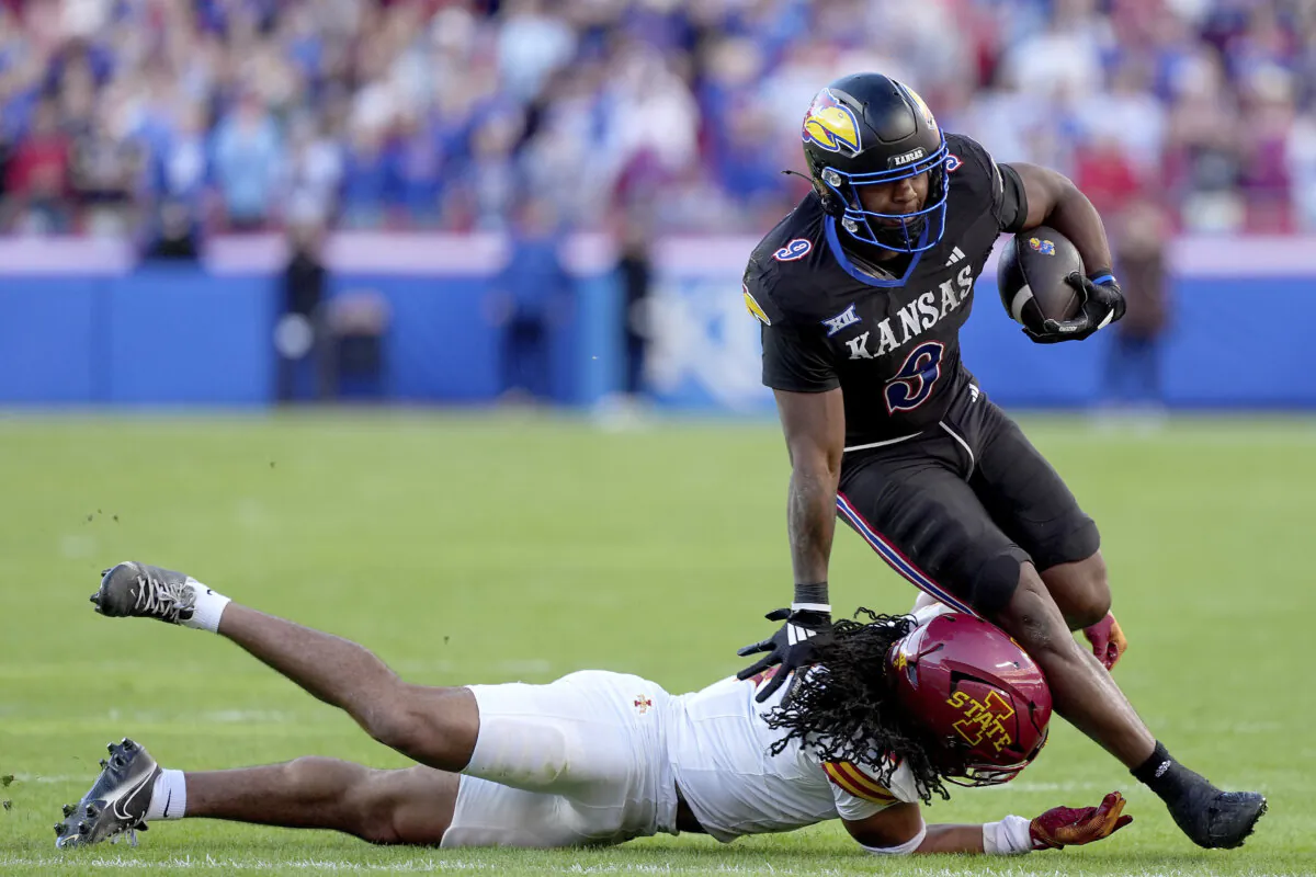 Kansas running back Daniel Hishaw Jr. (9) is tackled by Iowa State defensive back Jamison Patton (2) during the first half of an NCAA college football game Saturday, Nov. 9, 2024, in Kansas City, Mo. (AP Photo/Charlie Riedel)