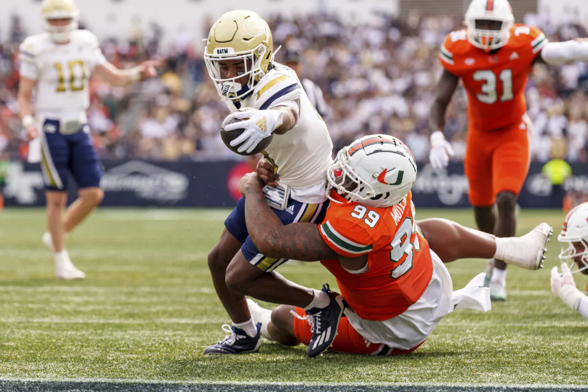 Georgia Tech wide receiver Malik Rutherford, left, reaches over the goal line while being tackled by Miami defensive lineman Ahmad Moten Sr. (99) during the first half of an NCAA college football game, Saturday, Nov. 9, 2024, in Atlanta. (AP Photo/Jason Allen)