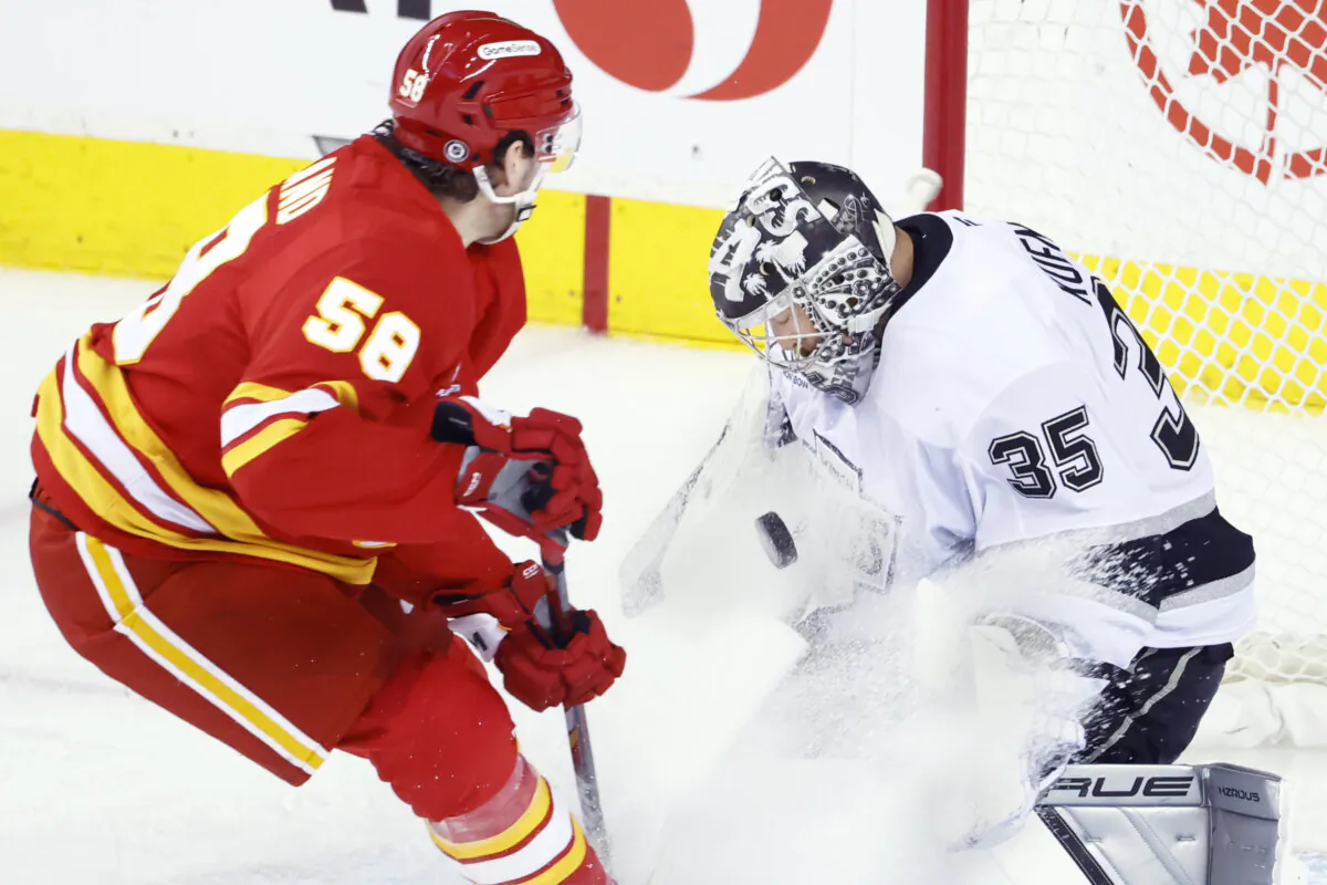 Los Angeles Kings goalie Darcy Kuemper (35) makes a save against Calgary Flames' Justin Kirkland (58) during second-period NHL hockey game action in Calgary, Albetrta, on Nov. 11, 2024. (Larry MacDougal/The Canadian Press via AP)