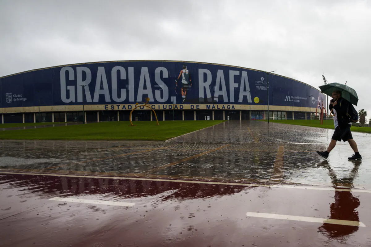 A man walks in front a banner reading in Spanish: "Thank you Rafa" during the Billie Jean King Cup finals at the Martin Carpena sportshall in Malaga, southern Spain, Wednesday, Nov. 13, 2024, after today's matches were canceled due to heavy rain and postponed until tomorrow. (Manu Fernandez/AP Photo)