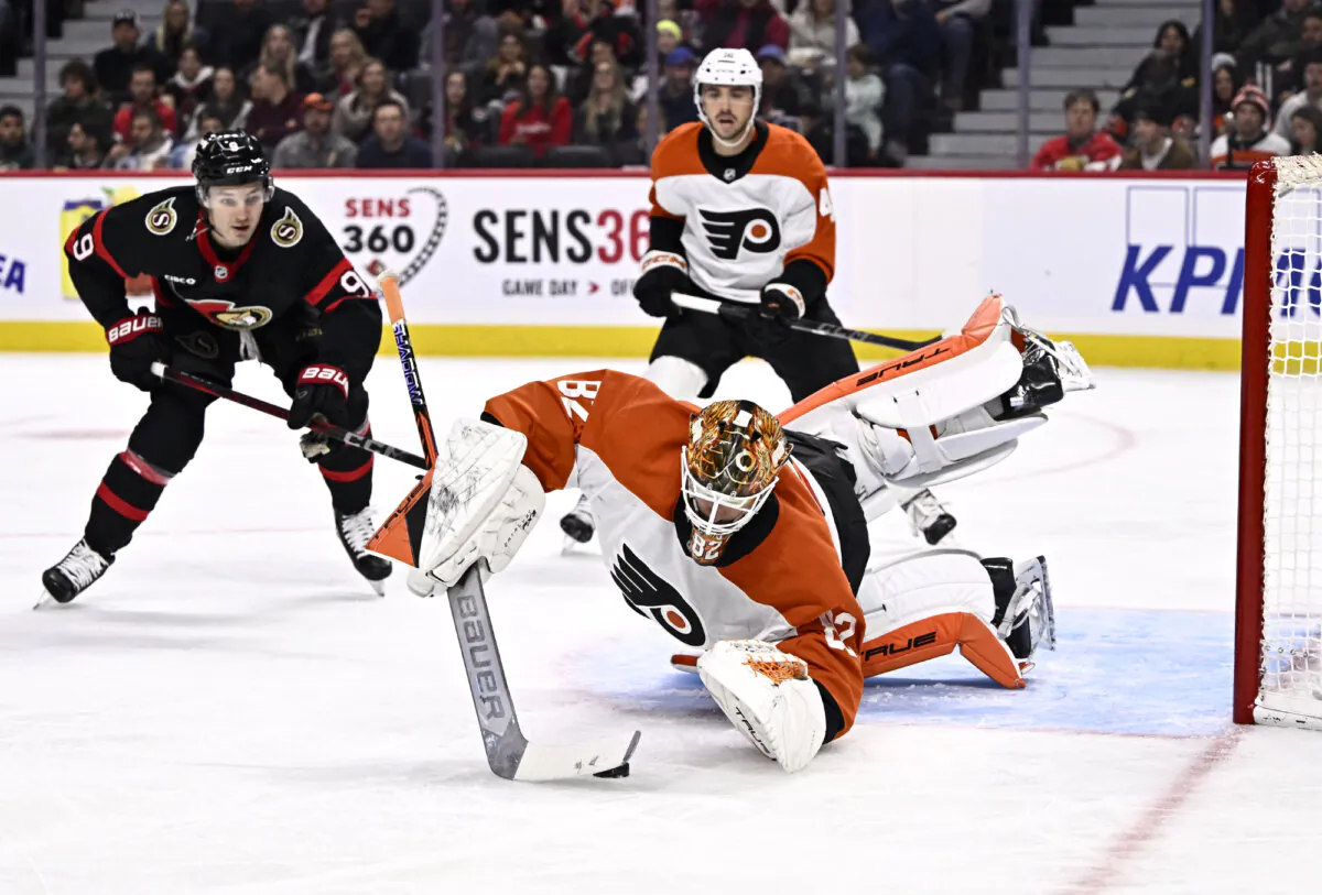 Philadelphia Flyers goaltender Ivan Fedotov (82) dives to cover the puck in front of Ottawa Senators center Josh Norris (9) during second-period NHL hockey game action in Ottawa, Ontario, on Nov. 14, 2024. (Justin Tang/The Canadian Press via AP)