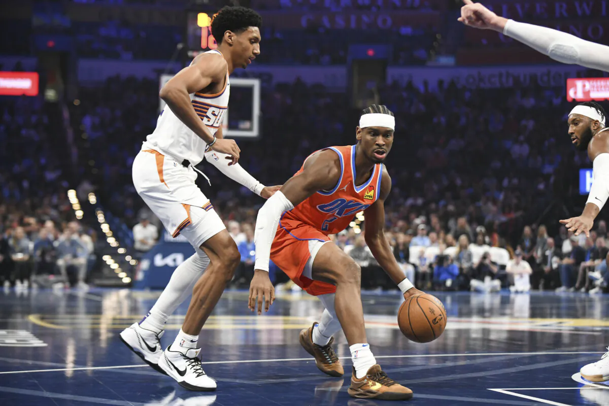 Oklahoma City Thunder guard Shai Gilgeous-Alexander, right, drives past Phoenix Suns forward Ryan Dunn, left, during the first half of an Emirates NBA Cup basketball game in Oklahoma City, on Nov. 15, 2024. (Kyle Phillips/AP Photo)