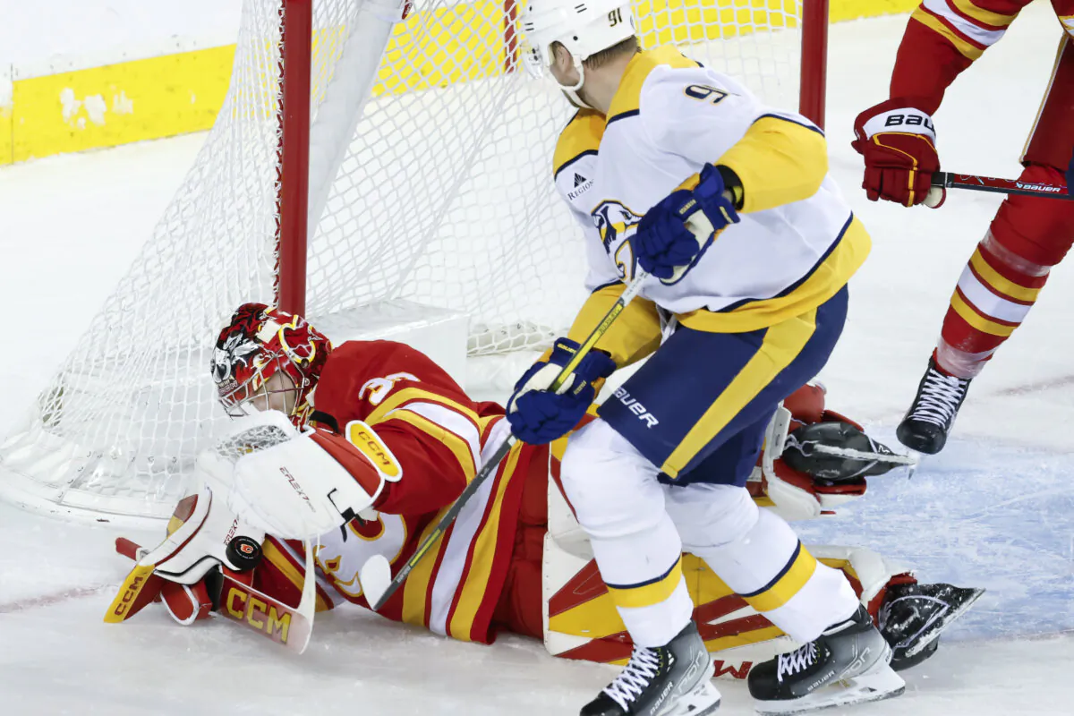 Nashville Predators' Steven Stamkos, center, is stopped by Calgary Flames goalie Dustin Wolf during the second period of an NHL hockey game in Calgary, Alberta, on Nov. 15, 2024. (Larry MacDougal/The Canadian Press via AP)
