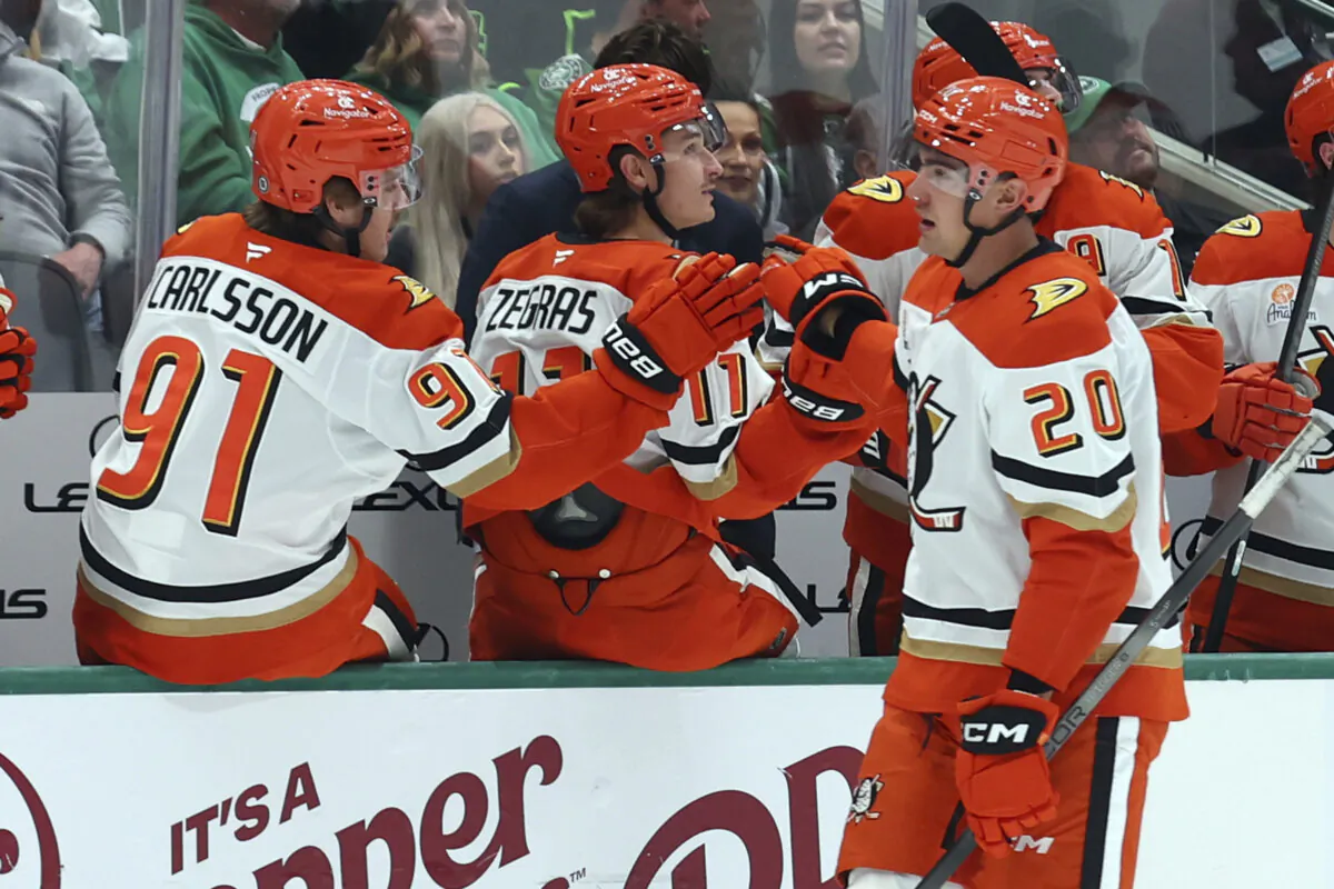 Anaheim Ducks centers Leo Carlsson (91) and Trevor Zegras (11) celebrate after a goal by right wing Brett Leason (20) in the first period of an NHL hockey game against the Dallas Stars in Dallas, on Nov. 18, 2024. (Richard W. Rodriguez/AP Photo)