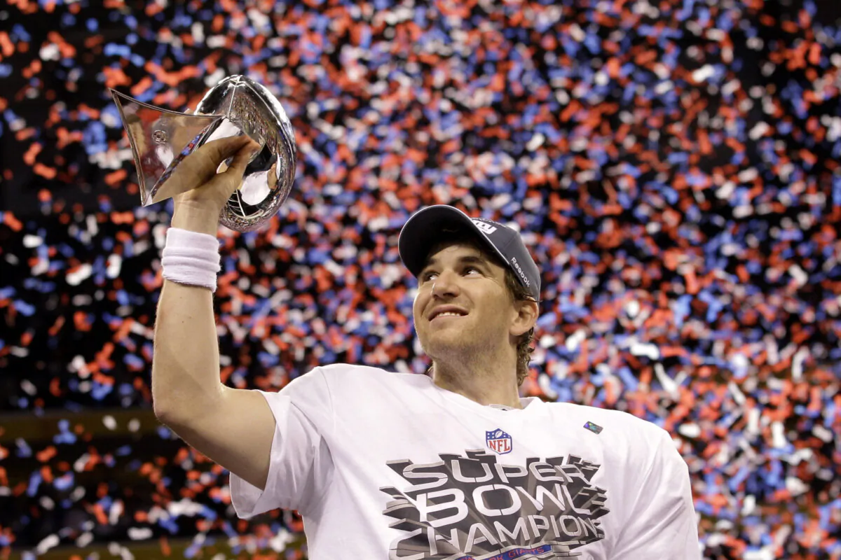 New York Giants quarterback Eli Manning holds up the Vince Lombardi Trophy while celebrating his team's 21-17 win over the New England Patriots in the NFL Super Bowl XLVI football game in Indianapolis on Feb. 5, 2012. (David J. Phillip/AP Photo)
