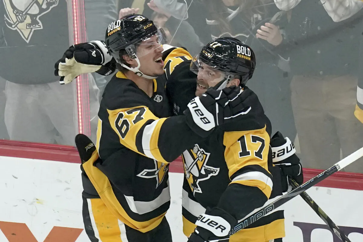 Pittsburgh Penguins' Rickard Rakell (67) celebrates with Bryan Rust (17) after scoring during the first period of an NHL hockey game against the Vancouver Canucks, Wednesday, Nov. 27, 2024, in Pittsburgh. (Matt Freed/AP Photo)