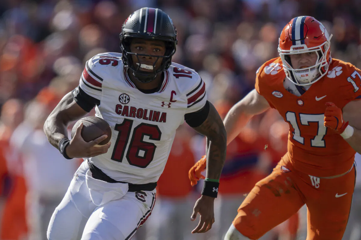 South Carolina quarterback LaNorris Sellers (16) runs with the ball while pursued by Clemson linebacker Wade Woodaz (17) in the first half of an NCAA college football game Saturday, Nov. 30, 2024, in Clemson, S.C. (Jacob Kupferman/AP Photo)