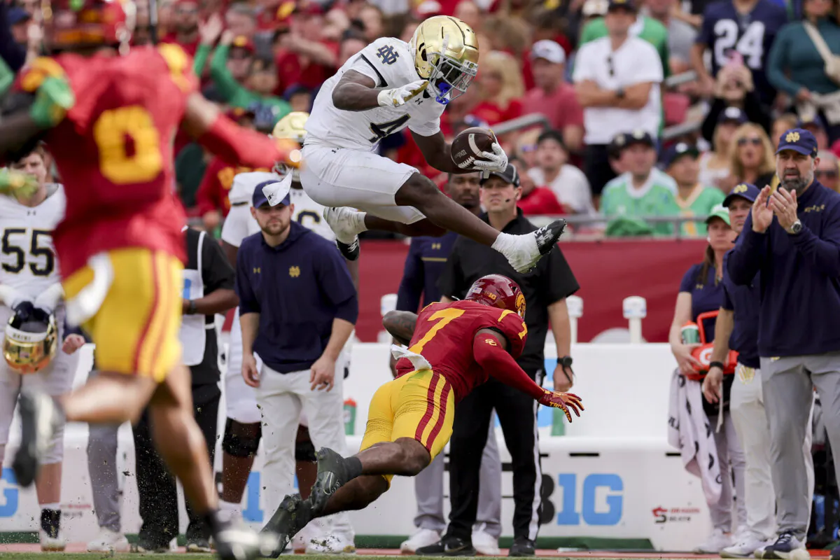 Notre Dame running back Jeremiyah Love, top, hurdles Southern California safety Kamari Ramsey during the first half of an NCAA football game, Saturday, Nov. 30, 2024, in Los Angeles. (Ryan Sun/AP Photo)