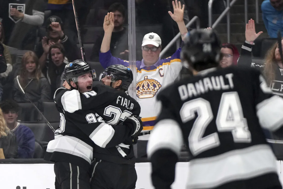 Los Angeles Kings left wing Kevin Fiala, center, celebrates his goal with defenseman Brandt Clarke, left, as center Phillip Danault skates in during the second period of an NHL hockey game against the Ottawa Senators, Saturday, Nov. 30, 2024, in Los Angeles. (Mark J. Terrill/AP Photo)