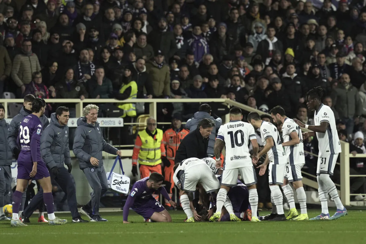 Fiorentina's Edoardo Bove, injured, is surrounded by players during the Serie A soccer match between Fiorentina and Inter at the Artemio Franchi Stadium in Florence, Italy, on Dec. 1, 2024. (Massimo Paolone/LaPresse via AP)