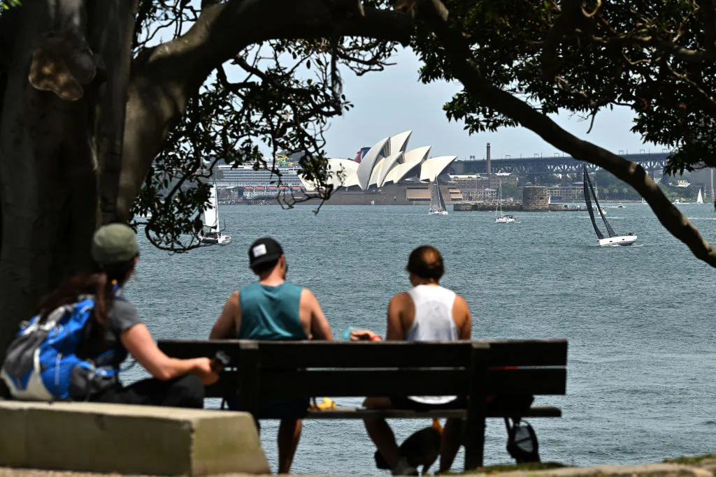 Visitors spend their morning under a large tree at Bradleys Head in Sydney, overlooking the Opera House on Nov. 3, 2024. (SAEED KHAN/AFP via Getty Images)