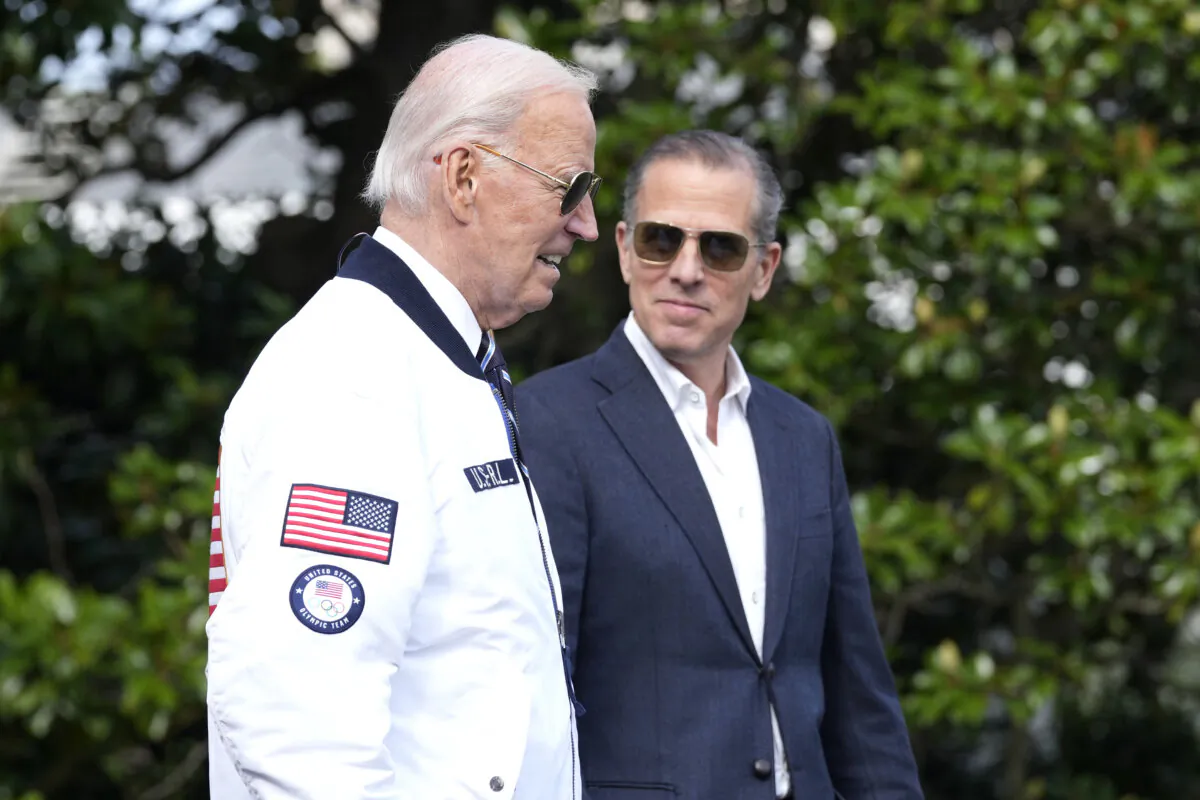 President Joe Biden, wearing a Team USA jacket and walking with his son Hunter Biden, heads toward Marine One on the South Lawn of the White House in Washington on July 26, 2024. (Susan Walsh/AP Photo)