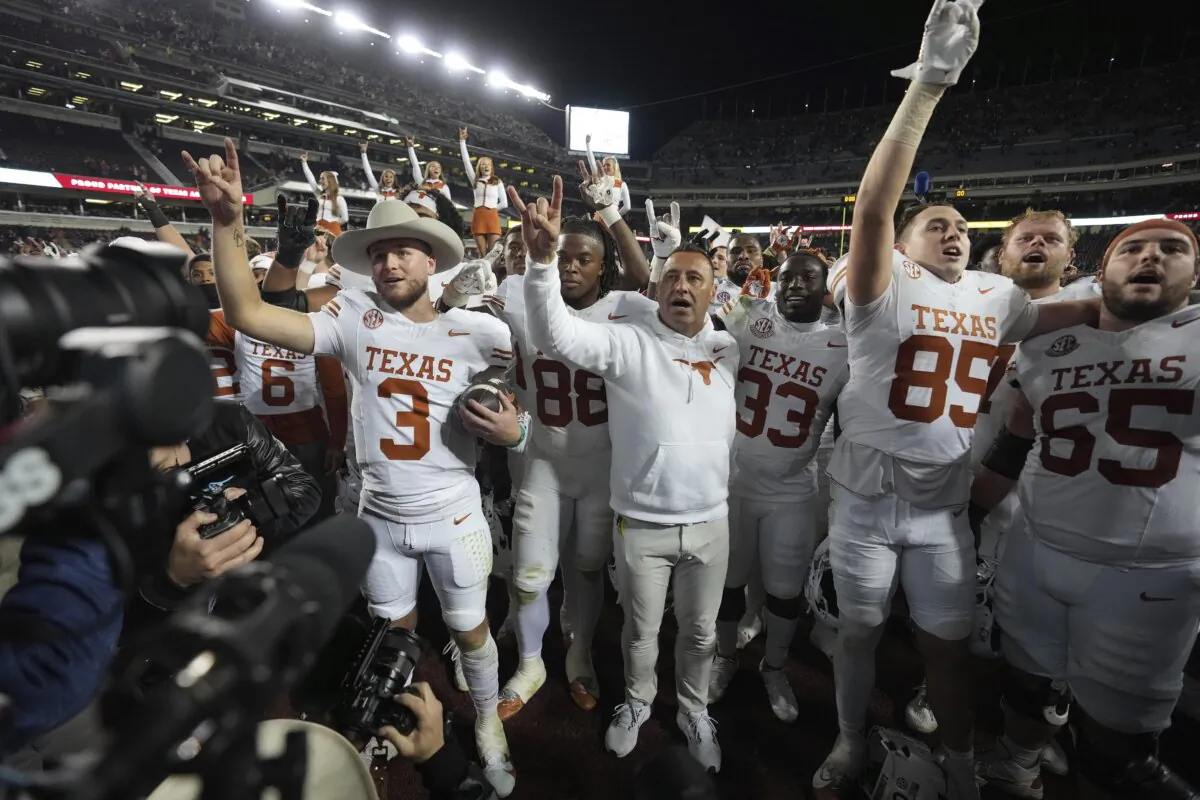 Texas head coach Steve Sarkisian, center, along with quarterback Quinn Ewers, left, and the rest of the Longhorns, after beating Texas A&M in an NCAA college football game in College Station, Texas on Nov. 30, 2024. (Sam Craft/AP Photo)