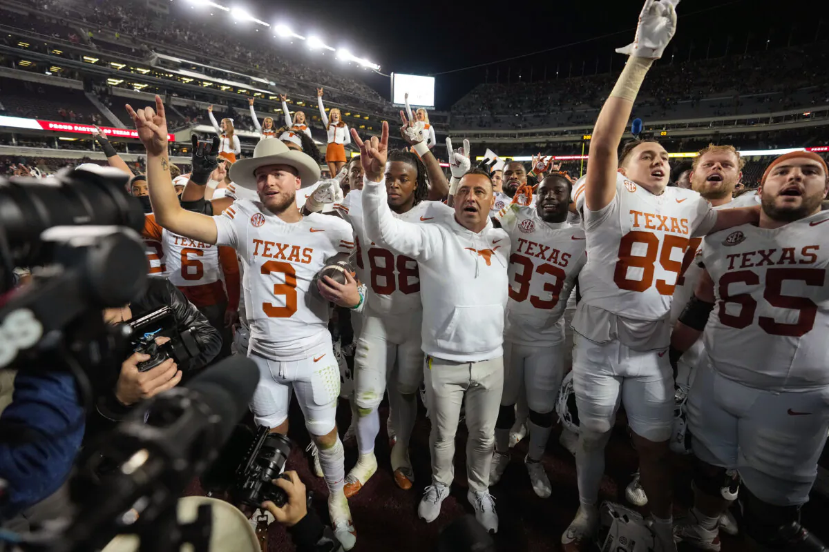 Texas head coach Steve Sarkisian, center, along with quarterback Quinn Ewers, left, and the rest of the Longhorns, after beating Texas A&M in an NCAA college football game in College Station, Texas on Nov. 30, 2024. (Sam Craft/AP Photo)