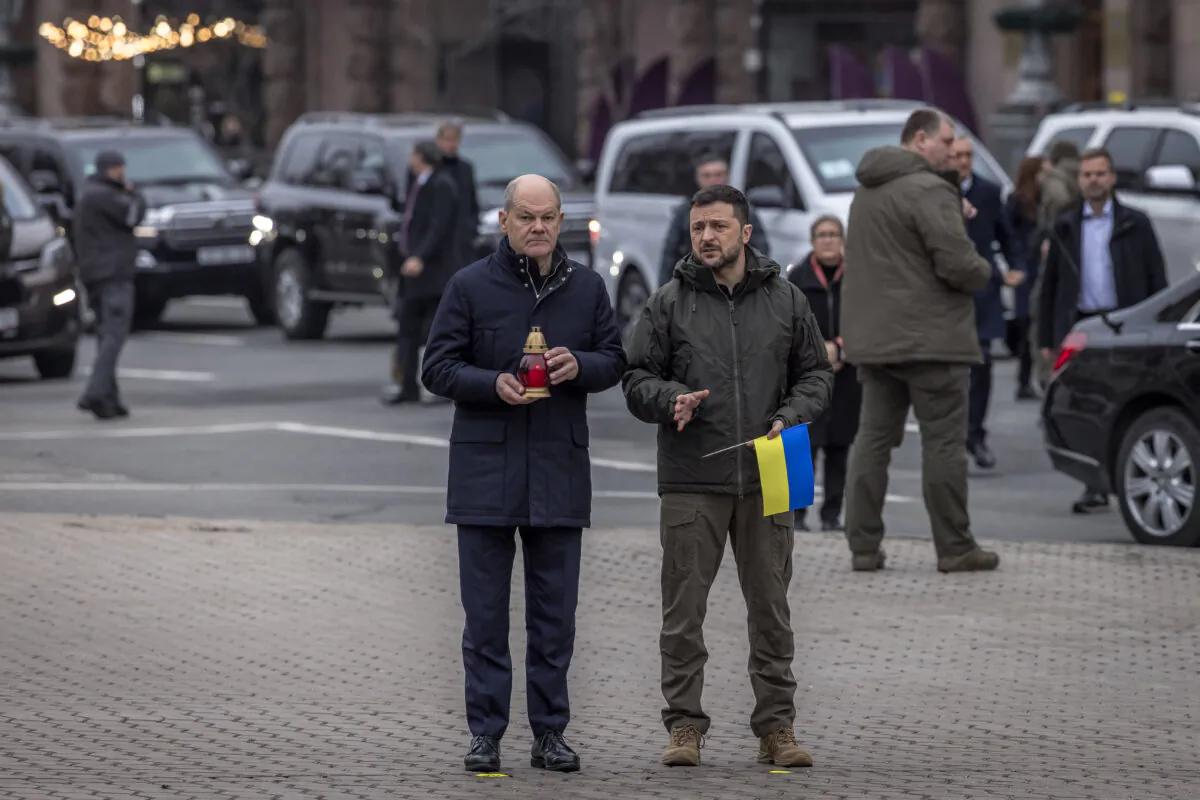 Ukrainian President Volodymyr Zelensky (R) and German Chancellor Olaf Scholz (L) visit the makeshift memorial paying tribute to Ukrainian and foreign fighters at the Independence Square in Kyiv, on Dec. 2, 2024, ( Roman Rilipey/AFP via Getty Images)