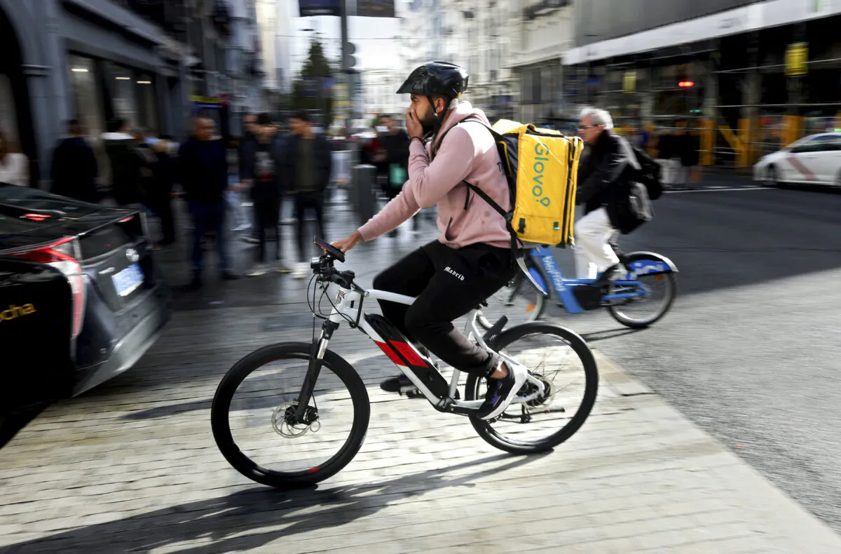 A Glovo rider cycles in Madrid on Dec. 2, 2024. Glovo is owned by Germany's Delivery Hero. (Thomas Coex/AFP via Getty Images)