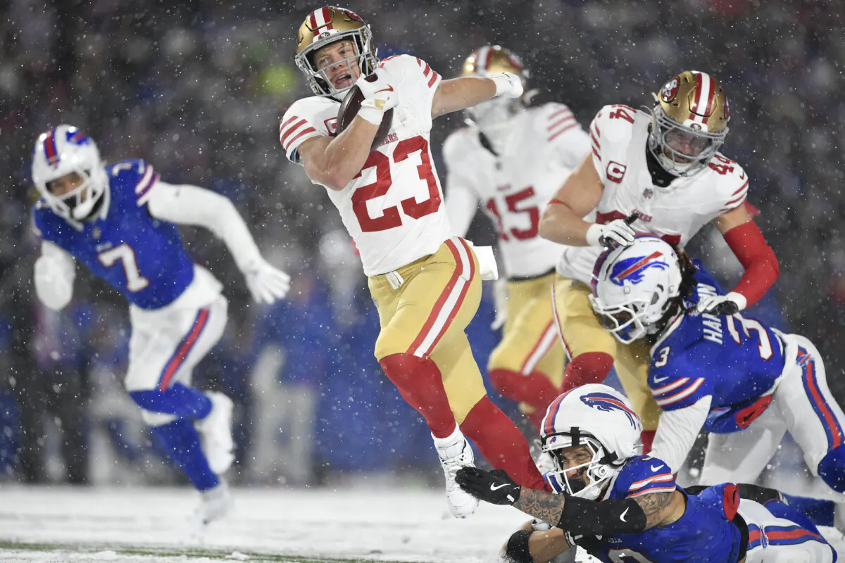 San Francisco 49ers running back Christian McCaffrey (23) runs against Buffalo Bills safety Taylor Rapp, bottom, during the first half of an NFL football game in Orchard Park, N.Y., on Dec. 1, 2024. (AP Photo/Adrian Kraus)