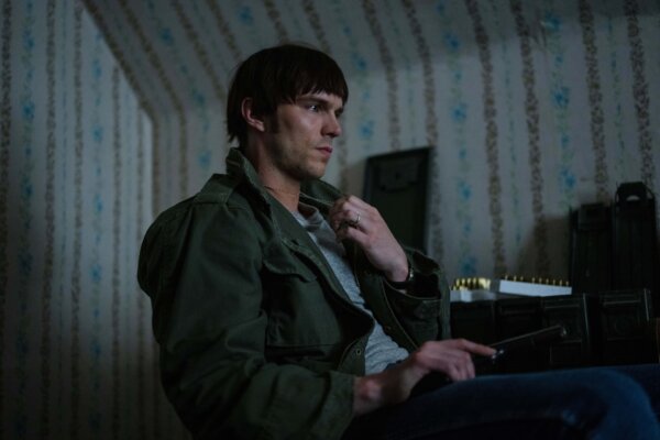 man with green jacket and gun in The Order