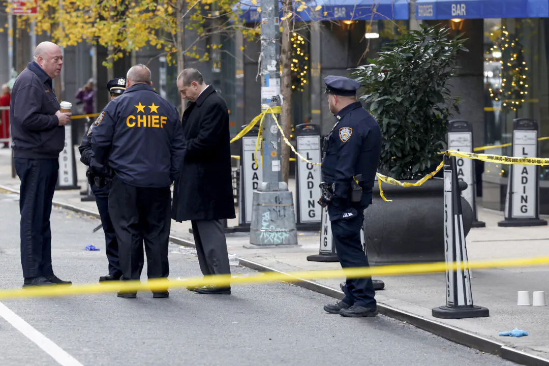 Police officers stand near the scene where the CEO of United Healthcare Brian Thompson was reportedly shot and killed in Midtown Manhattan, in New York City, on Dec. 4, 2024. (Shannon Stapleton/Reuters)