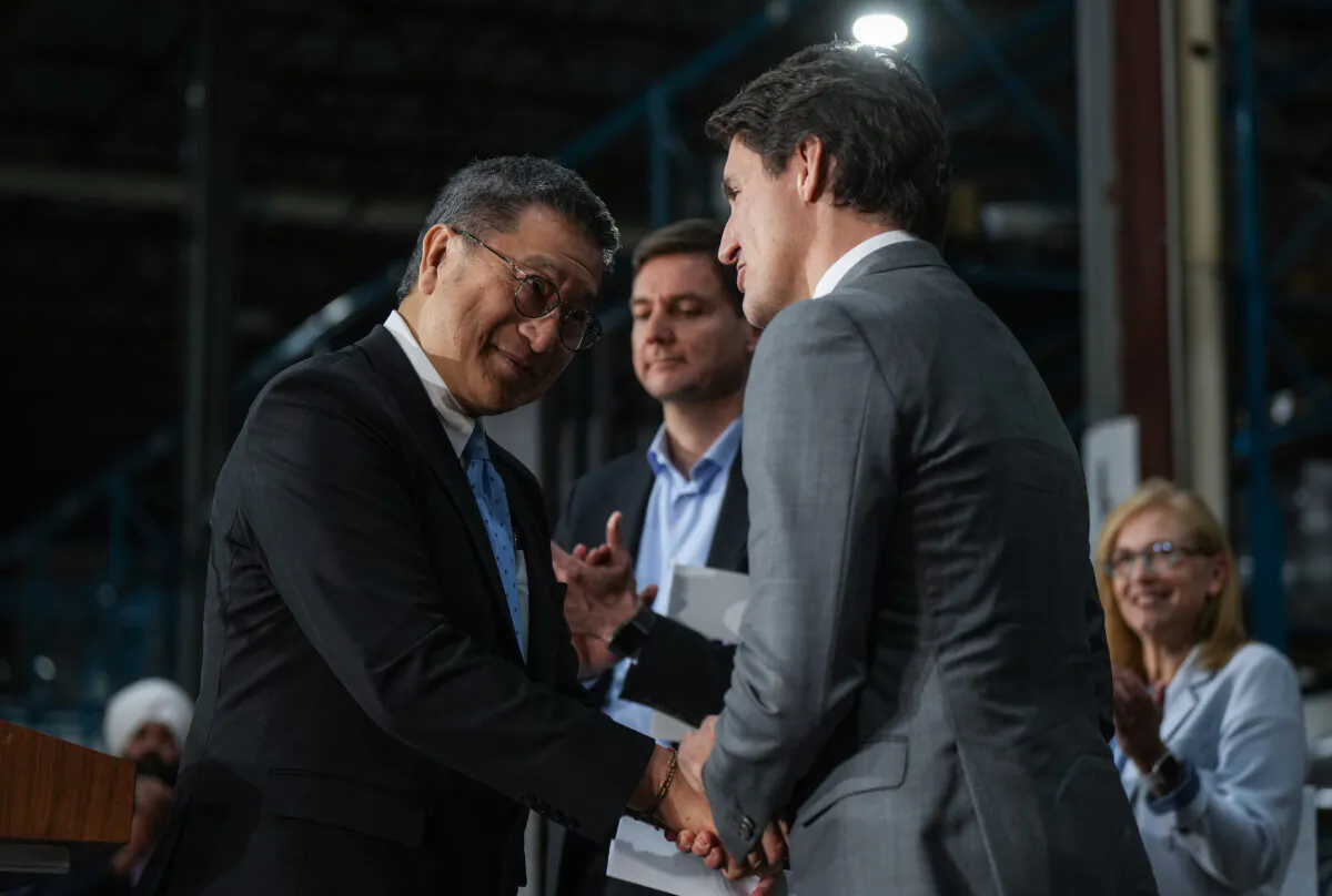 Nelson Chang (L) Chairman of TCC Group, E-One Moli Energy (Canada), shakes hands with Prime Minister Justin Trudeau after a news conference at the lithium battery manufacturer, in Maple Ridge, B.C., on Nov. 14, 2023. (The Canadian Press/Darryl Dyck)