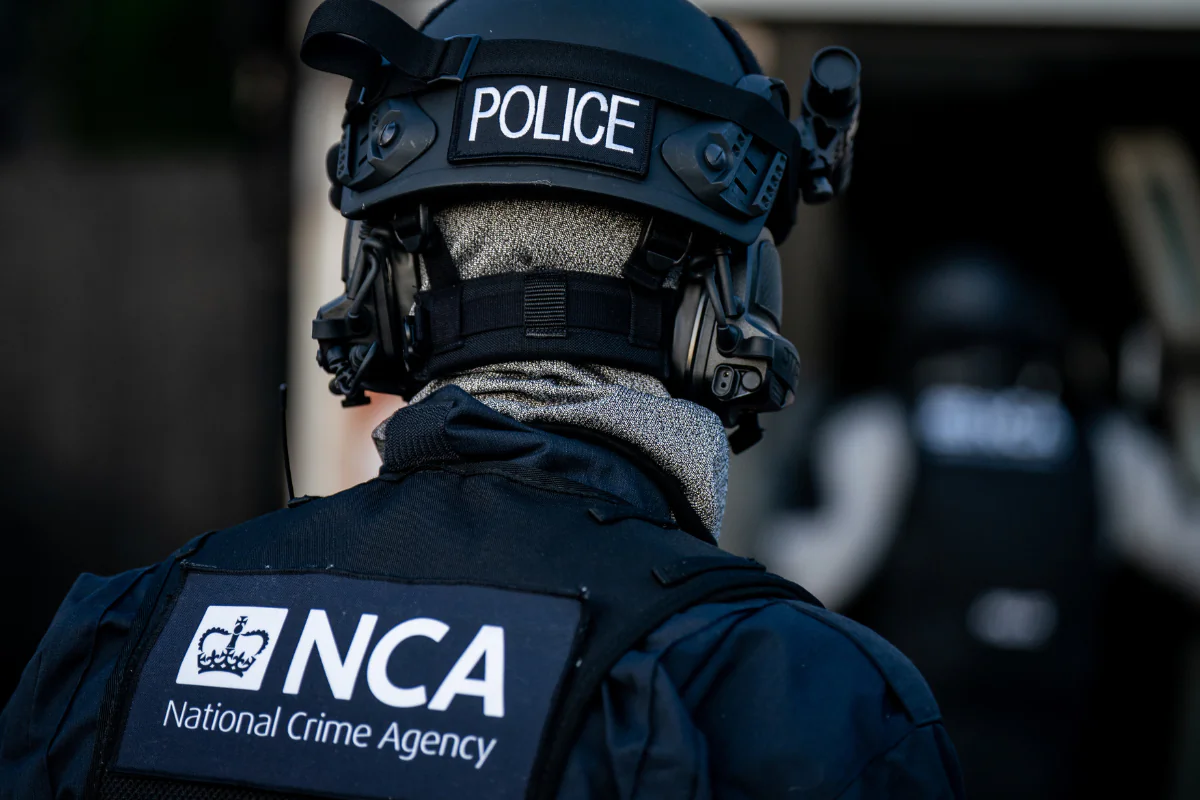Officers from the National Crime Agency arrive at a property of a man who is accused of being a member of a group arranging small boat crossings, in Grays, Essex, England, on June 19, 2023. (Aaron Chown/PA)