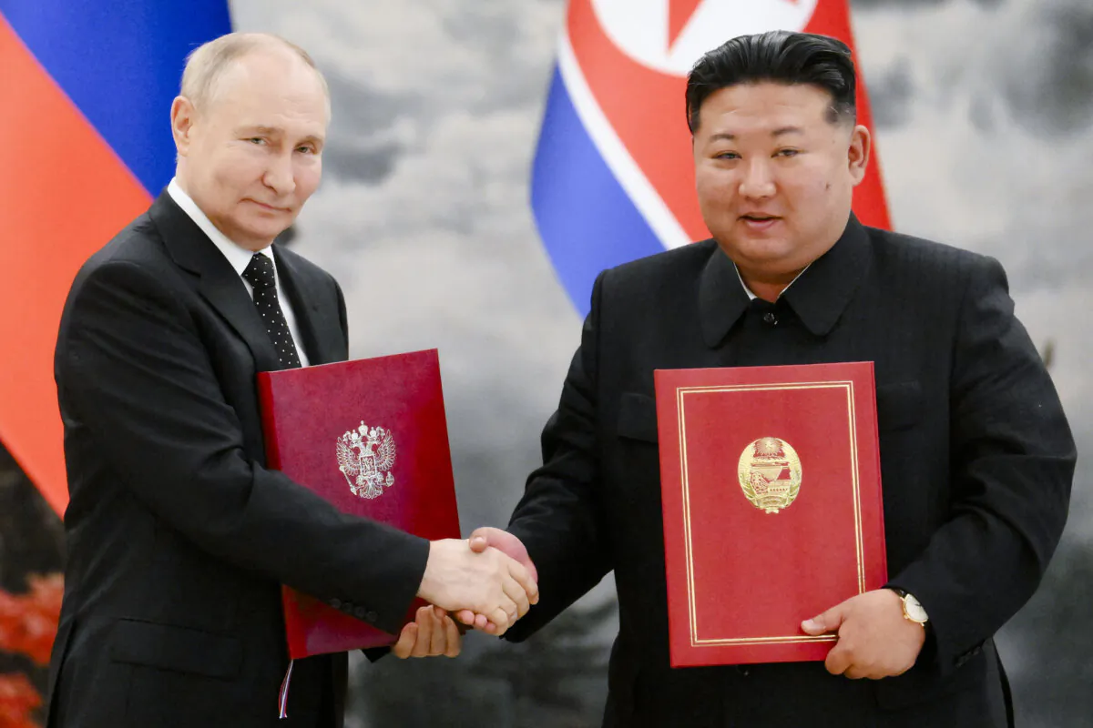 In this pool photograph distributed by the Russian state agency Sputnik, Russian President Vladimir Putin (L) shakes hands with North Korean leader Kim Jong Un after a signing ceremony following their bilateral talks at Kumsusan state residence in Pyongyang, North Korea, on June 19, 2024. (Kristina Kormilitsyna / Pool/AFP via Getty Images)