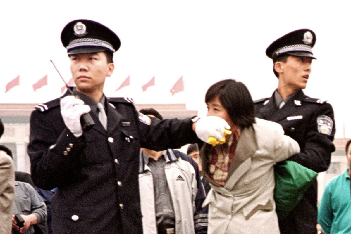 Two Chinese police officers arrest a Falun Dafa adherent at Tiananmen Sqaure in Beijing on Jan. 10, 2000. (Chien-Min Chung/AP Photo)