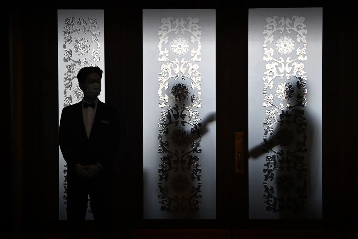 Security guards stand behind a glass door at the Great Hall of the People during the 14th National People's Congress in Beijing on March 6, 2024. (Greg Baker/AFP via Getty Images)