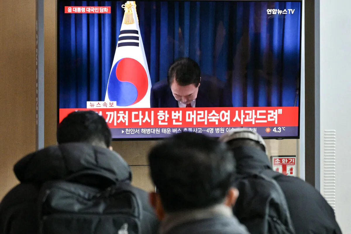 People watch a live television broadcast of South Korea's President Yoon Suk Yeol bowing after the end of his address, at a train station in Seoul, South Korea, on Dec. 7, 2024. (Anthony Wallace/AFP via Getty Images)