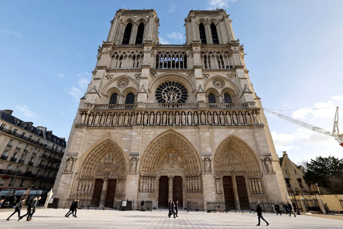 People walk in front of the Notre-Dame de Paris cathedral, ahead of its official reopening ceremony after more than five years of reconstruction work following the April 2019 fire, in Paris on Dec. 7, 2024. (Ludovic Marin/Pool/AFP via Getty Images)