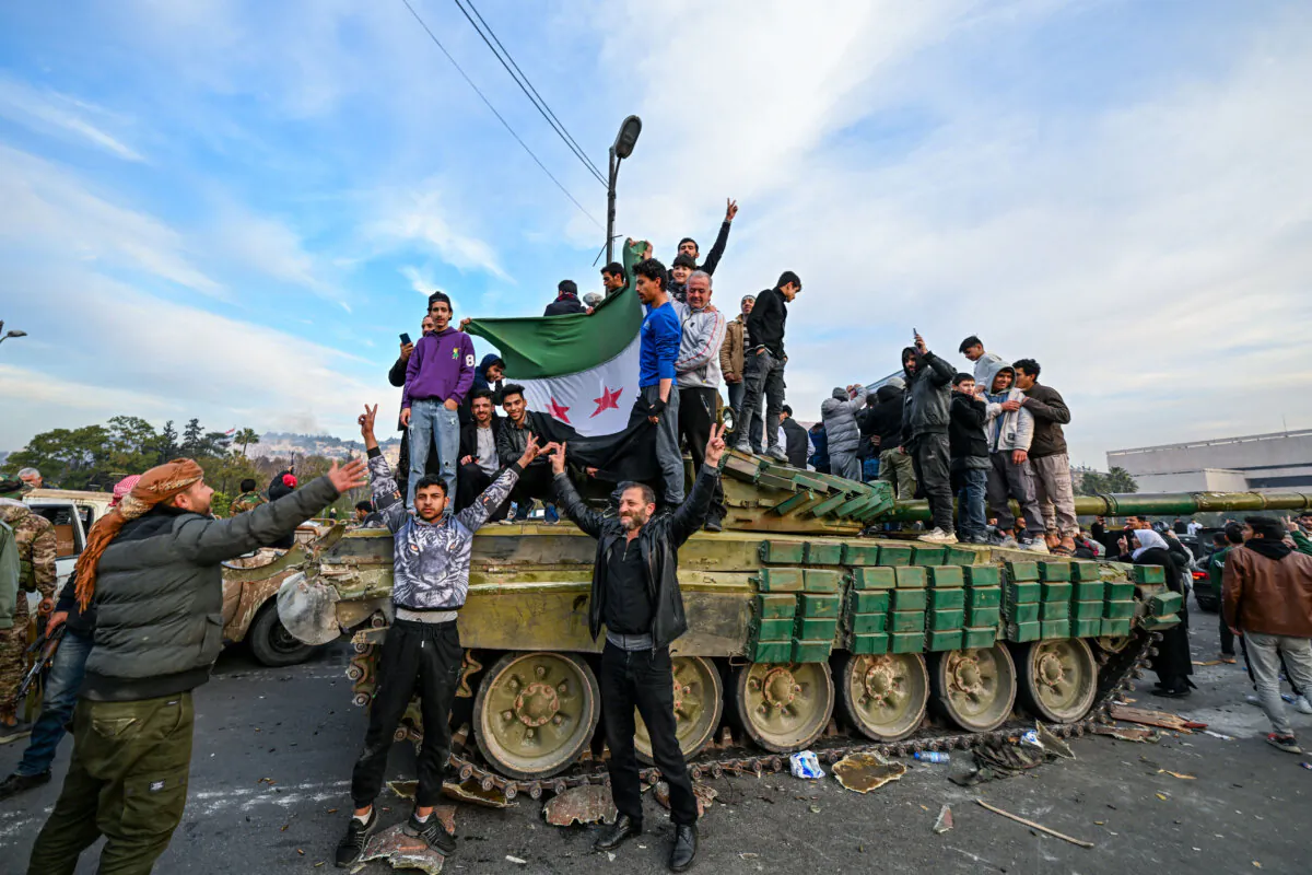 People celebrate with rebel fighters at Umayyad Square in Damascus, Syria, on Dec. 8, 2024. (Louai Beshara/AFP via Getty Images)