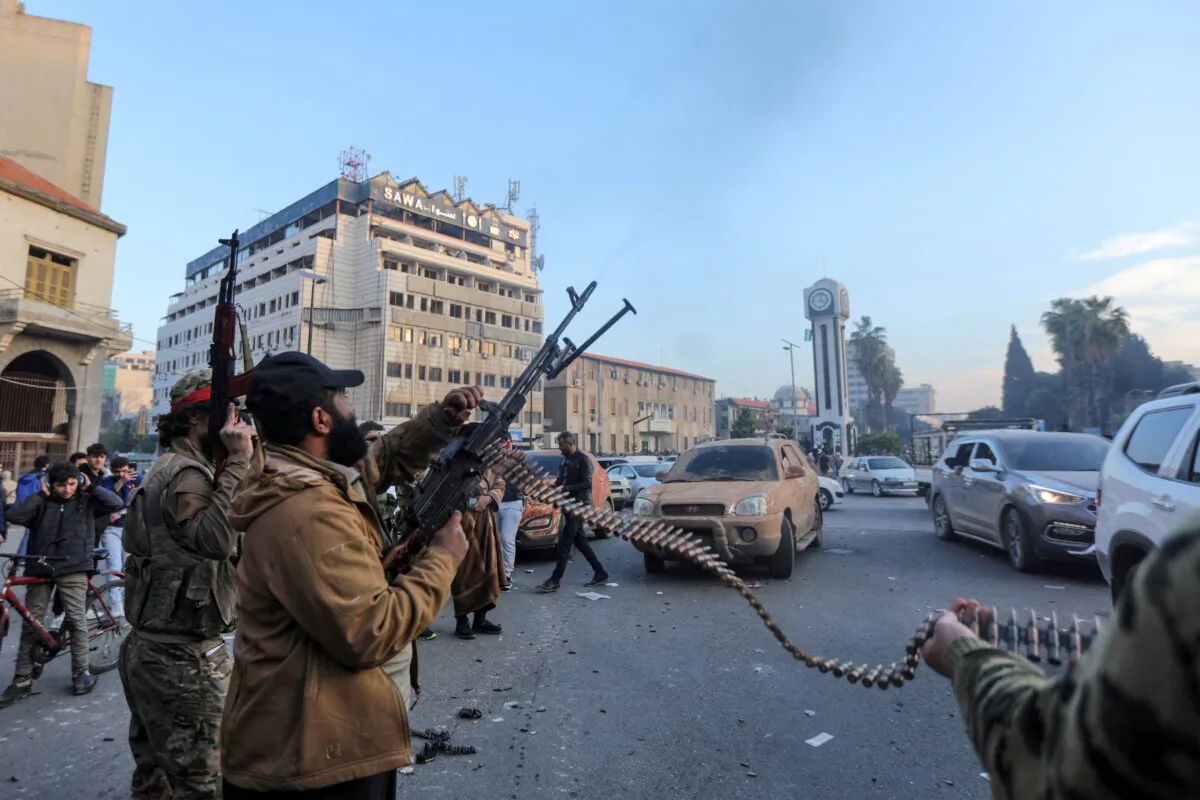 Rebel fighters fire in the air during celebrations in the heart of Homs, Syria, on Dec. 8, 2024. (Bakar Alkasem/AFP via Getty Images)