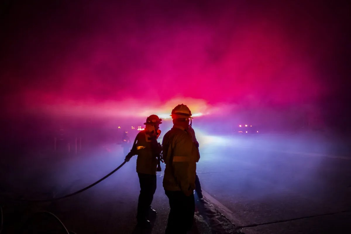 A Firefighter fights the Franklin Fire while it burns in the Pacific Coast Highway in the morning near Malibu, Calif., on Dec. 11, 2024. The wildfire has scorched 3890 acres near Pepperdine University prompting evacuations along the coast amid high winds with some homes destroyed. (Apu Gomes/Getty Images)
