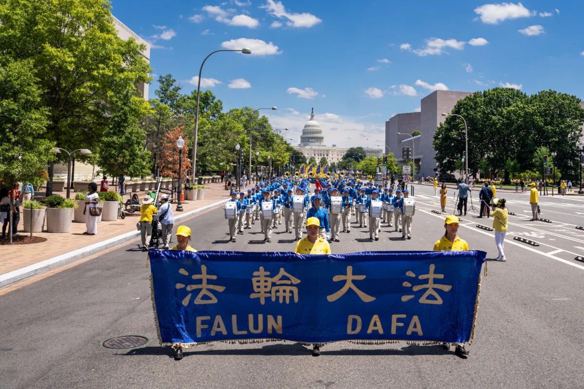 Falun Gong practitioners march during a parade calling for the end of the Chinese Communist Party’s 25 years of ongoing persecution of Falun Gong in China at the National Mall in Washington on July 11, 2024. (Madalina Vasiliu/The Epoch Times)