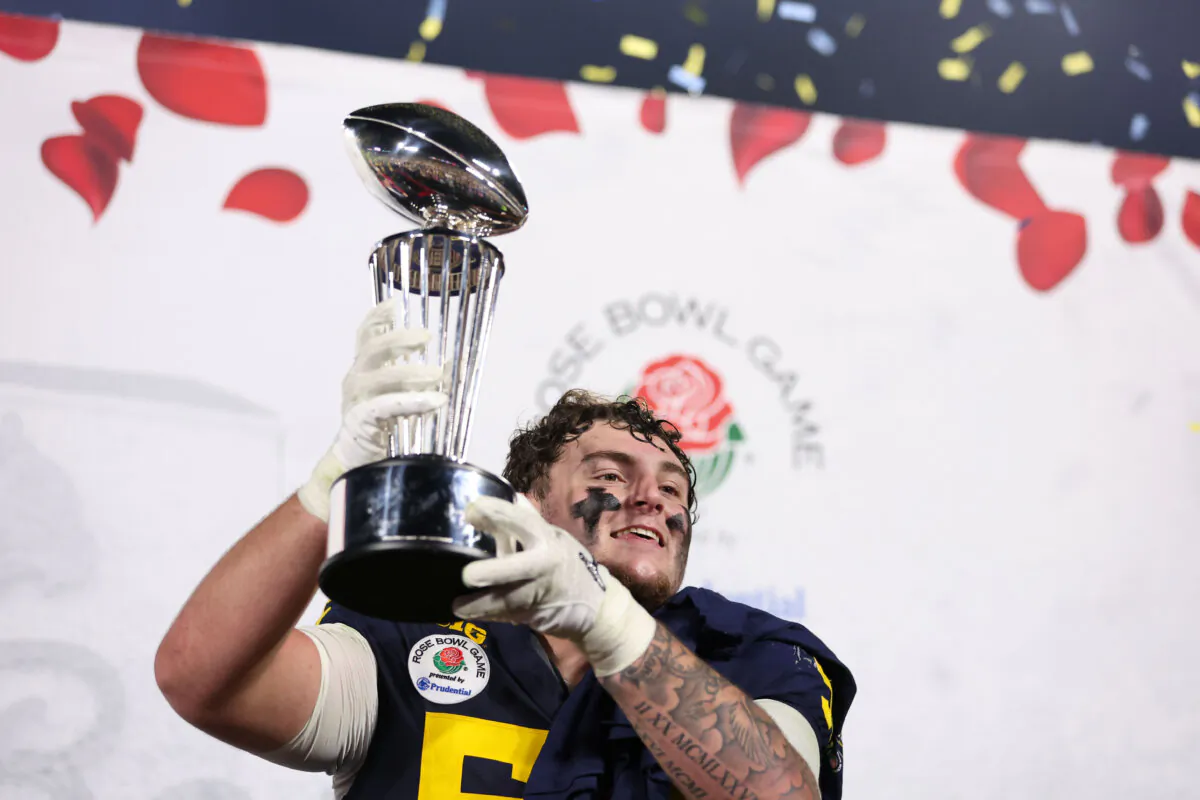 Mason Graham #55 of the Michigan Wolverines celebrates with The Leishman Trophy after beating the Alabama Crimson Tide 27–20 in overtime to win the CFP Semifinal Rose Bowl Game at Rose Bowl Stadium in Pasadena, Calif., on Jan. 1, 2024. (Sean M. Haffey/Getty Images)