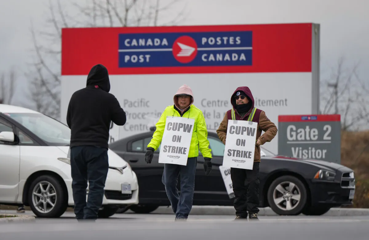 Members of the Canadian Union of Postal Workers (CUPW) picket outside the Canada Post Pacific Processing Centre in Richmond, B.C., on Nov. 27, 2024. (The Canadian Press/Darryl Dyck)