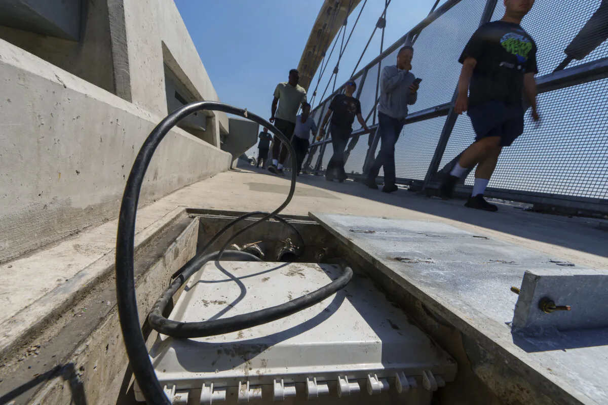 Pedestrians walk past a vandalized high voltage electric box on the 6th Street Viaduct, on Aug. 27, 2024, in Los Angeles, which has been damaged by copper wire theft. (Damian Dovarganes/The Canadian Press) 