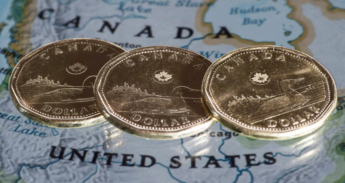 Canadian dollar coins, or loonies, are displayed on a map of North America in Montreal on Jan. 9, 2014. (The Canadian Press/Paul Chiasson) 