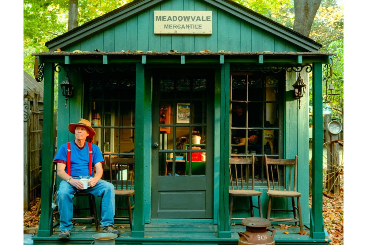 Terry Wilson sitting on the porch of one of his small buildings. (Courtesy of "Terry's Little Village", a short documentary from 2024)