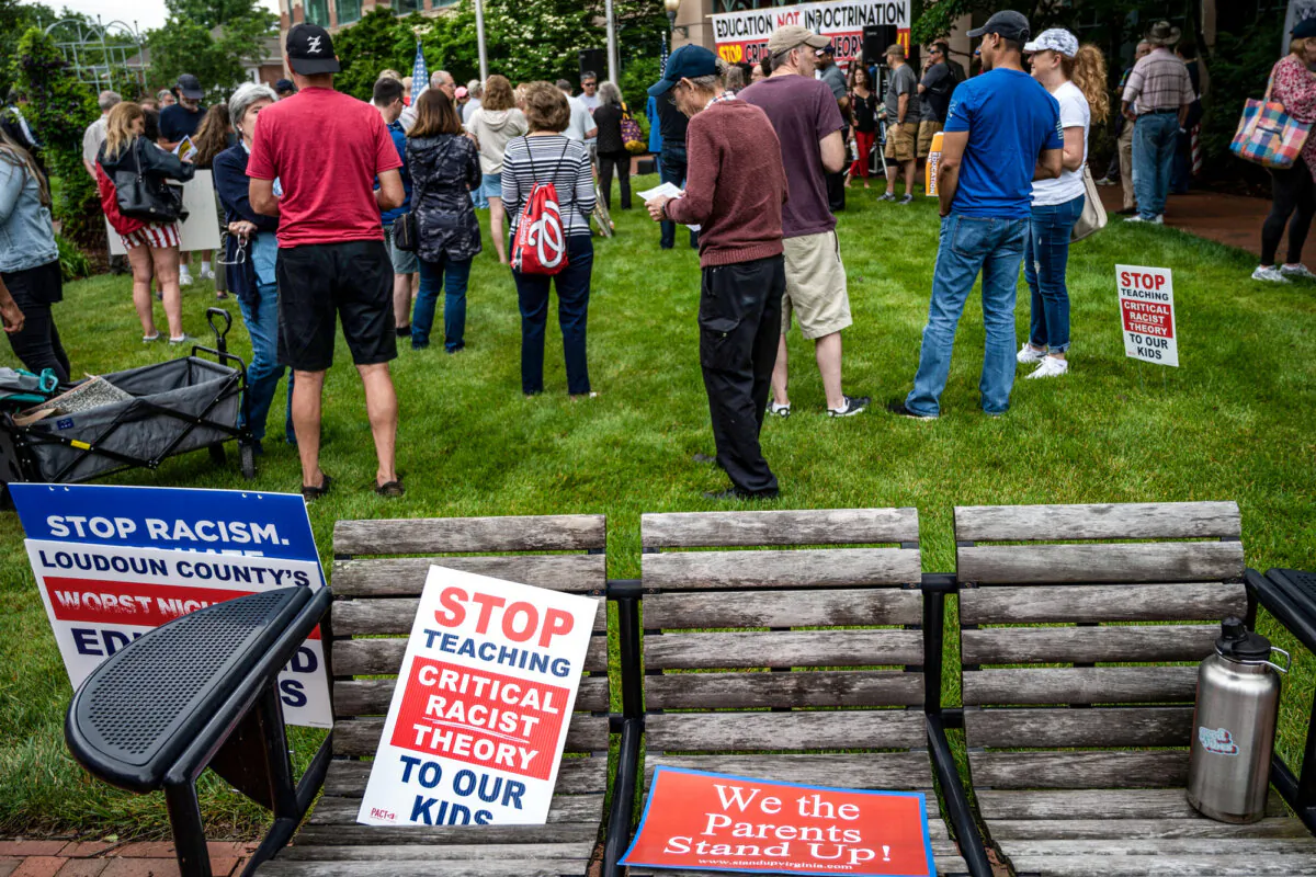 Signs lie on a bench during a rally against “critical race theory” being taught in schools at the Loudoun County Government center in Leesburg, Va., on June 12, 2021. (Andrew Caballero-Reynolds/AFP via Getty Images)