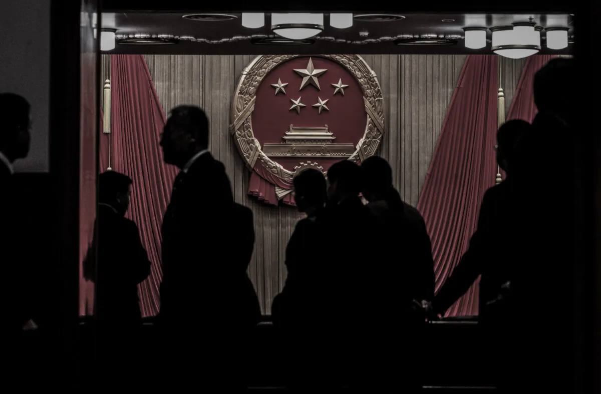 Delegates and security guards stand in the entranceway to the auditorium before the closing session of the National People's Congress at the Great Hall of the People in Beijing, on March 11, 2024. (Kevin Frayer/Getty Images)