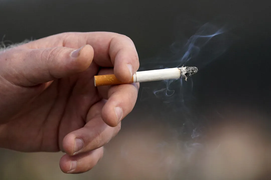 A man holds a lit cigarette in San Francisco on Dec. 2, 2020. (The Canadian Press/AP-Jeff Chiu)