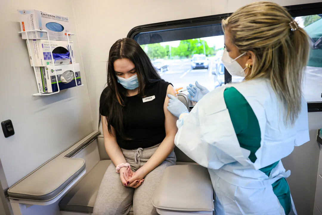 A 13-year-old receives a Pfizer-BioNTech COVID-19 vaccine from a registered nurse at the UHealth's pediatric mobile clinic in Miami, Fla., on May 17, 2021. (Joe Raedle/Getty Images)