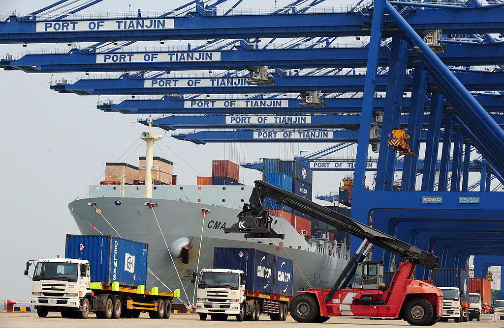 Containers are loaded onto delivery trucks after being unloaded off a cargo ship at Tianjin port in Tianjin, China, on June 26, 2008. (Frederic J. Brown/AFP via Getty Images)