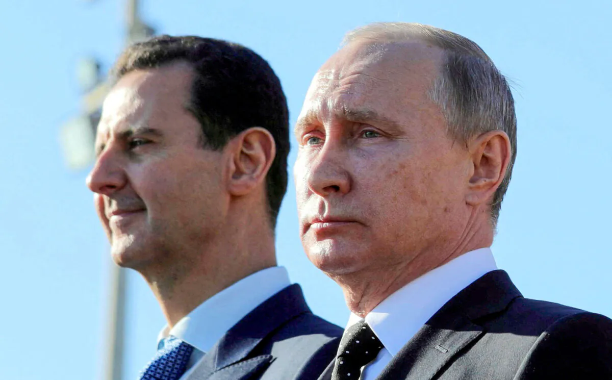 Russian President Vladimir Putin (R) stands beside Syrian President Bashar al-Assad, who was ousted in December 2024, at Hmeymim air base in Latakia, Syria, on Dec. 11, 2017. (Mikhail Klimentyev/Sputnik via Reuters)