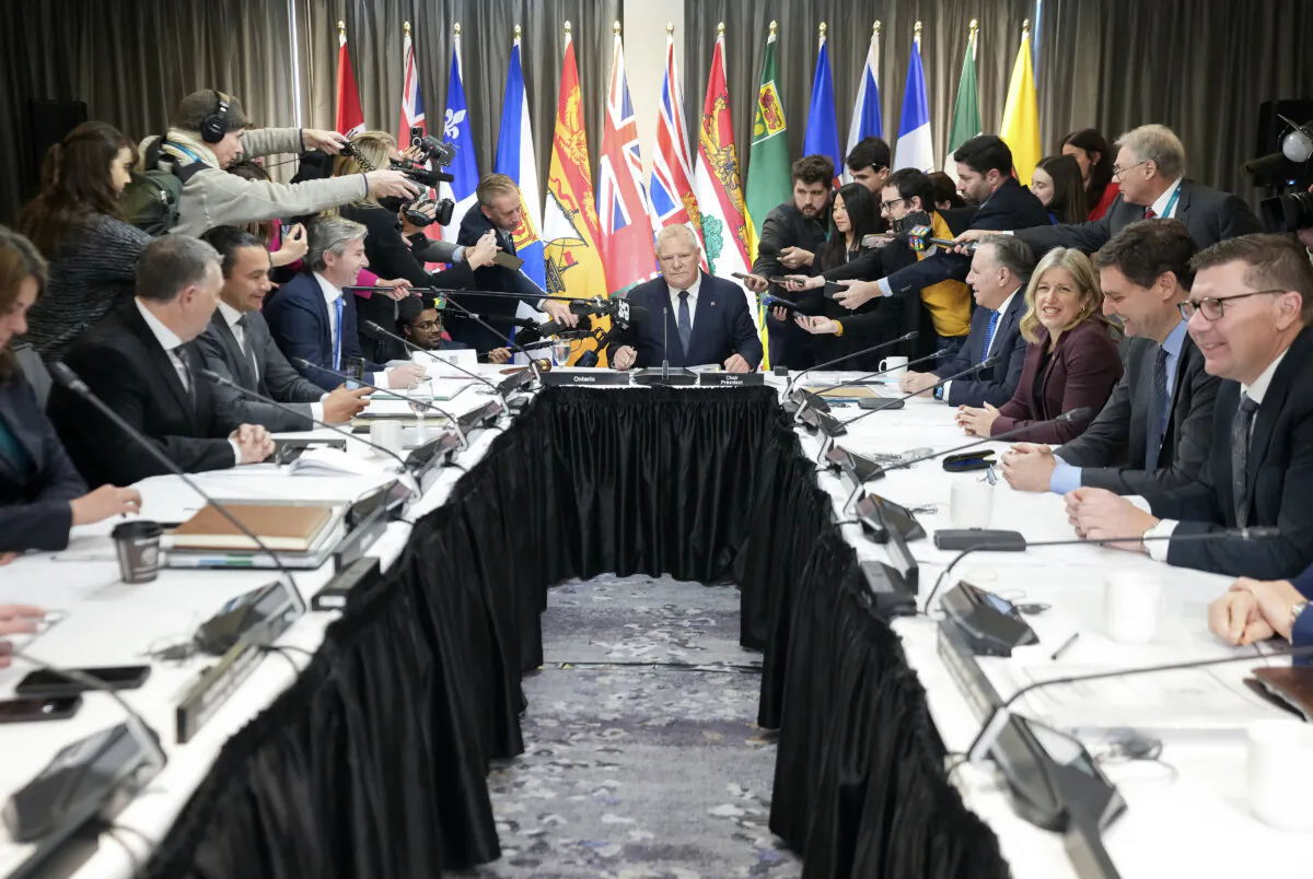 Ontario Premier Doug Ford (C} is swarmed by the media during the fall meetings of Canada's premiers hosted by Ontario in Toronto, on Dec. 16, 2024. (The Canadian Press/Nathan Denette)