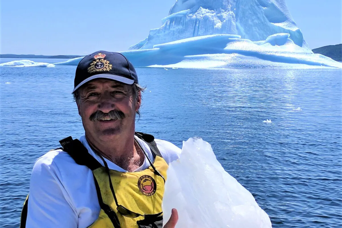 Barry Porter, a retired lighthouse keeper with the Canadian Coast Guard, poses near an iceberg off the coast of Newfoundland and Labrador. (Courtesy of Barry Porter)